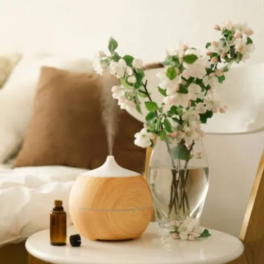 a diffuser and an essential oil on a bedside table