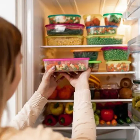 person storing food in the fridge