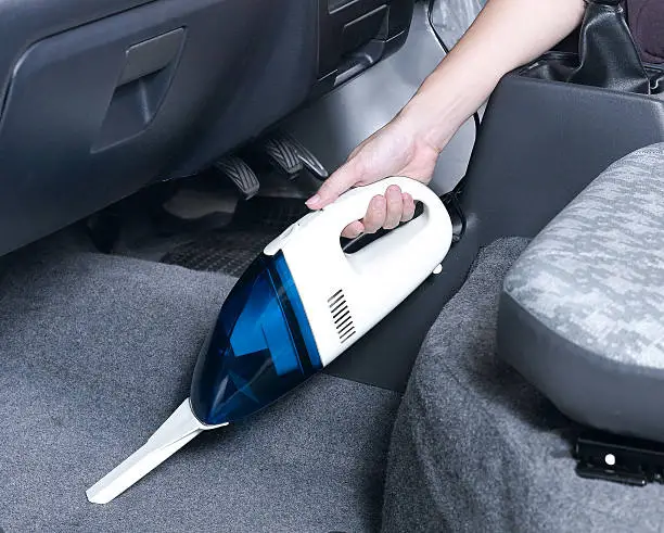cordless vacuum, removing the excess diatomaceous earth from car